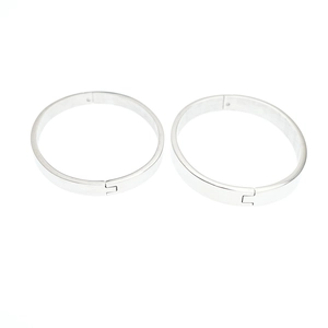 Minimalist silver oval titanium steel bangle with polished finish and snap closure