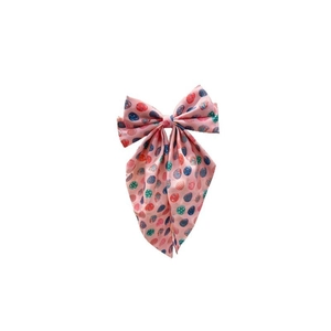 Close-up of pink ribbon hair bow with colorful Easter egg prints and fabric texture