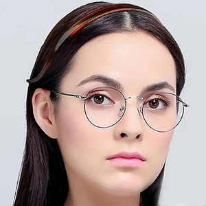 Close-up of a silver round metal frame glasses worn by a female model with a gray background