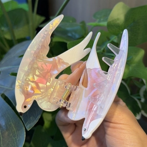 Detailed macro shot of the pearlescent swallow hair claw clip with pink marble texture