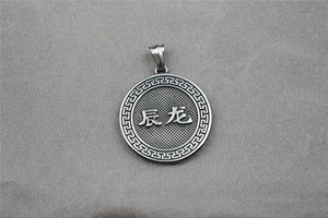 Macro detail of zodiac dragon pendant with traditional Greek pattern on vintage steel