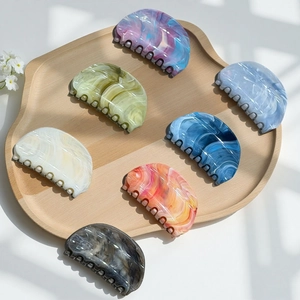Detail view of colorful marble textured acetate hair claws in various vibrant shades