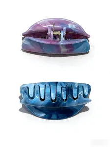 Detailed macro view of marble textured acetate hair claws with premium metal springs