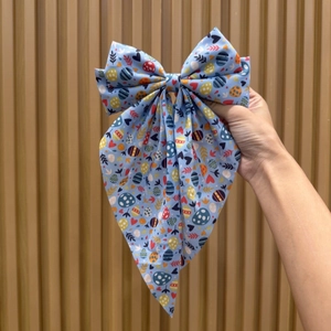 Easter bow hair clip with cute rabbit and colorful egg patterns on blue fabric