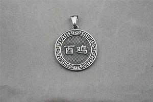 Macro shot of silver titanium steel necklace pendant featuring Chinese Zodiac Rooster engraving