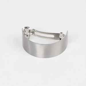 Detail of silver brushed metal hair clip showing the curved shape and spring mechanism