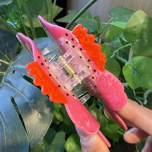 Detail of colorful trout fish hair claw clip featuring pink and orange polka dot patterns