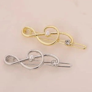 Fermagli per capelli a nota musicale oro e argento con perle e strass su sfondo rosa