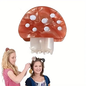 Detail of red mushroom hair claw clip with white dots and acetate teeth on white background