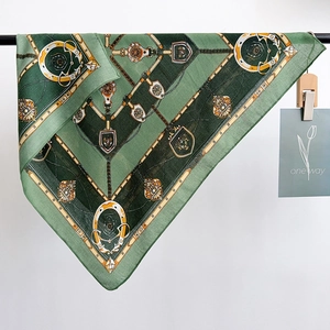 Green equestrian silk scarf with luxury horse-bit pattern on white background