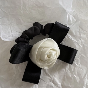 Chouchou élégant en satin noir avec une rose en tissu blanc et rubans délicats