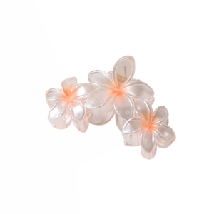 Détail macro d'une pince à cheveux fleur de frangipanier 9cm nacrée aux pétales roses