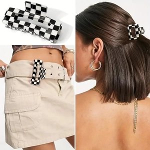 Details einer schwarz-weißen Schachbrett-Haarklammer für Frisuren und als Gürtel-Accessoire