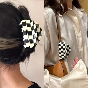 Details einer Haarklammer mit Schachbrettmuster als Haarschmuck und Taschenanhänger