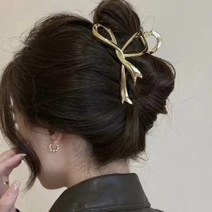 Molla per capelli dorata a forma di fiocco per acconciature eleganti su modella