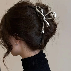 Pinza per capelli a fiocco in metallo argento su un'acconciatura a chignon