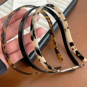 Detail shot of slim acetate headbands with non-slip teeth in tortoiseshell and solid colors