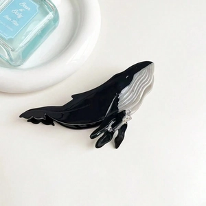 Dettaglio del fermaglio per capelli a forma di balena in acetato lucido nero e bianco