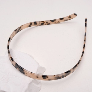 Close-up of tortoise shell pattern acetate headband with non-slip teeth detail