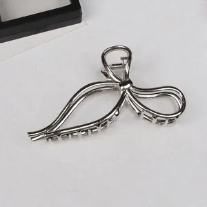 Dettaglio di un fermaglio per capelli in metallo argento lucido con design a fiocco