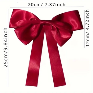 Nœud de cheveux en satin rouge avec longs rubans et dimensions 20 cm par 25 cm sur blanc