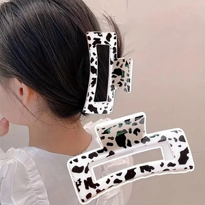 Close-up of rectangular cow print hair claws showing the glossy finish and secure grip