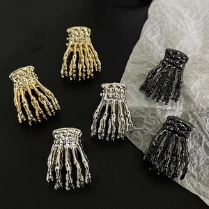 Gothic Totenkopf-Hand-Haarklammern in Gold, Silber und Gunmetal auf dunklem Leder