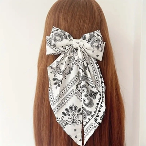 Bohemian paisley bow hair clip with long ribbons shown on long brown hair back view