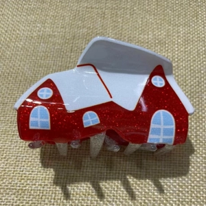 Detail of red glitter Christmas house hair claw clip with snow-covered roof design