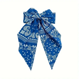 Detailed macro view of the dark blue paisley pattern on the bow-knot fabric hair clip