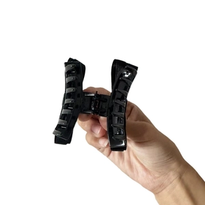 Pinza per capelli nera lucida con struttura a H simmetrica e denti a forte presa