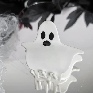 Pince à cheveux fantôme blanc poli pour Halloween sur une surface miroir chic