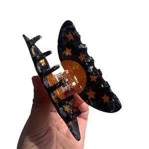 Acetate hair claw clip with black marble texture and orange stars for women