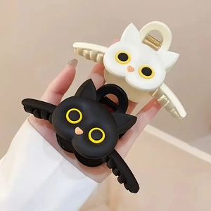 Gros plan de pinces à cheveux chat mates en noir et crème avec détails des yeux
