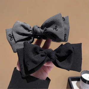 Set of two oversized bow hair clips in black and grey patterns for elegant styling