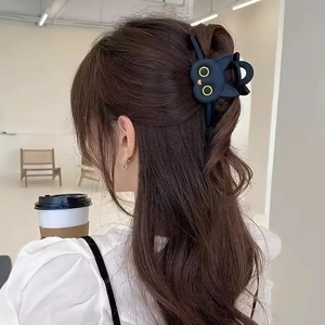 Pince à cheveux chat noir mignonne portée par un mannequin dans un cadre naturel
