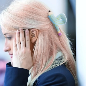 Detailansicht einer kreativen blauen Haarklammer in Bleistiftform im Haar einer Frau