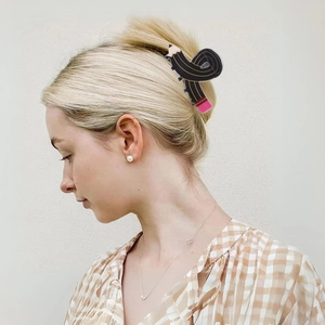 Detailansicht einer süßen Haarspange in Bleistiftform mit goldenen Streifen und Radiergummi