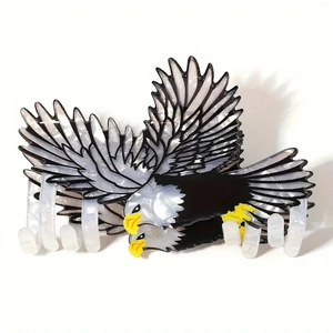 Vue détaillée d'une grande pince à cheveux en forme d'aigle en acétate noir et blanc