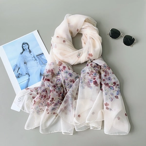 Elegant light blue floral silk scarf for women displayed with fashion magazine and sunglasses