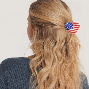 Detail einer herzförmigen Haarklammer mit US-Flagge in gewelltem blondem Haar von hinten