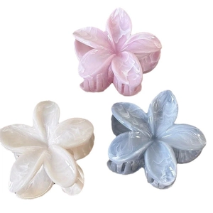 Frangipani flower hair claws in pink, blue, and white with marble texture finish