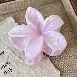 Detailed macro view of a pink marble pattern frangipani hair claw clip with acetate texture