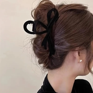 Side view of large black velvet bow hair claw clip styled in an elegant French updo