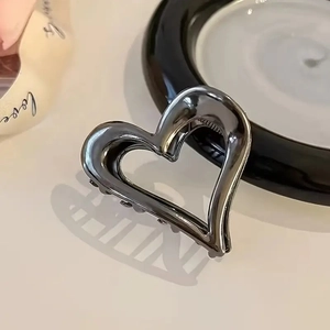 Detalle de una pinza para el cabello de metal con forma de corazón en gris metalizado