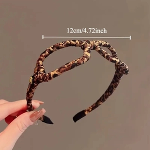 Elegant leopard print twist headband with gold button detail and 12cm width