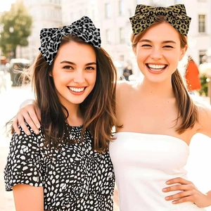 Detail of elegant leopard print bow headbands in yellow and grey fabric for women