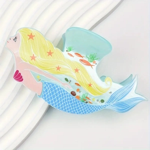 Close-up of a cartoon mermaid hair claw clip with blue scales and starfish details