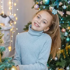 Cute blue snowflake hair claw clip worn by a model in a cozy Christmas setting