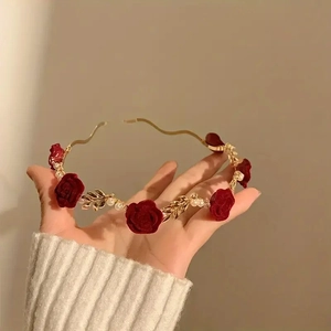 Detail of red velvet rose and pearl headband with gold filigree leaves